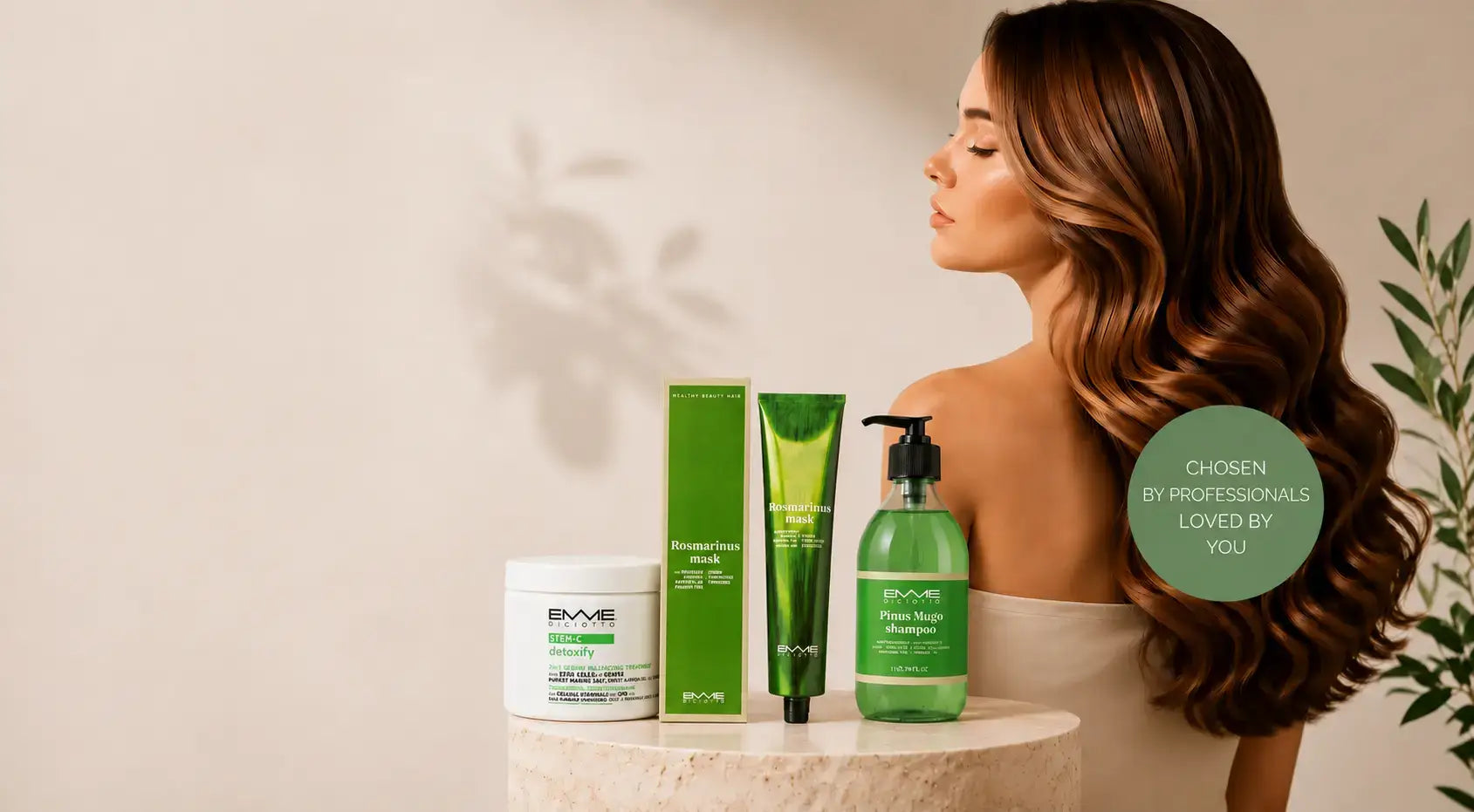 Professional Emme Diciotto botanical hair care products displayed on a stone pedestal with a brunette model showcasing healthy, glossy wavesslider_item_AjVnga